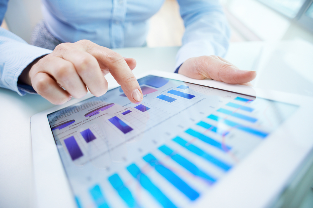 Womans hand interacting with data on tablet