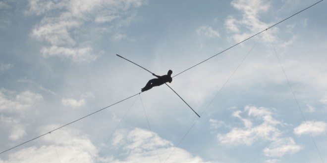 person walking across trapeze wire